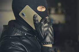 mężczyzna w kominiarce rozmawia przez telefon