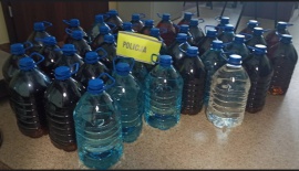 zabezpieczone plastikowe pojemniki z nielegalnym alkoholem