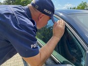 policjant zagląda przez okno samochodu