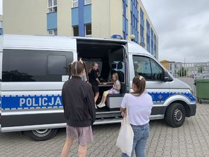 Policjantka siedzi na podłodze z dziećmi-spotkanie profilaktyczne