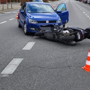 na drodze znajdują się uszkodzony vw i motorower