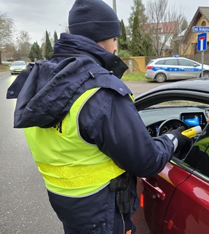 Policjant bada trzeźwość kierowcy