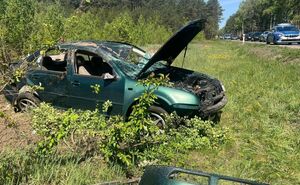 uszkodzony po dachowaniu vw, w tle policyjny radiowóz