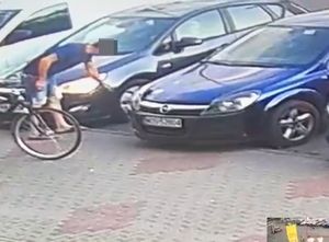 screen z monitoringu, na zdjęciu zaparkowane pojazdy i wizerunek ( twarz zasłonięta) pasażera sprawcy