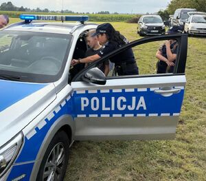 Policjantka pokazuje na pikniku dzieciom radiowóz