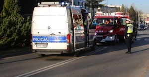 Policjanci pracujący na miejscu potrącenia, w tle radiowóz