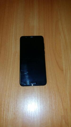 Zdjęcie pokazuje czarny telefon typu smartphone na biurku