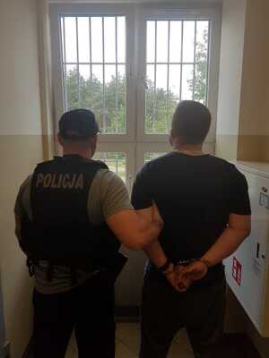 Zdjęcie przedstawiające policjanta z zatrzymanym mężczyzną