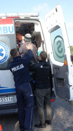 Zdjęcie poglądowe. Policjant pomaga Seniorowi wejść do karetki pogotowia