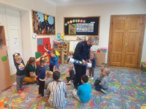 Dzielnicowy Wydziału Prewencji Komendy Miejskiej Policji w Ostrołęce pokazuje dzieciom ze Szkoły Podstawowej w Przystani, jak działają odblaski za pomocą Magicznej Tuby.