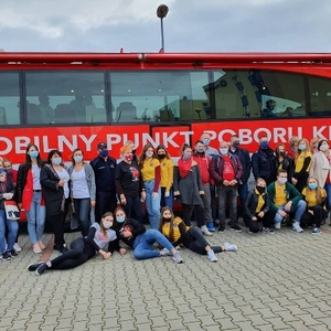 Wspólne zdjęcie organizatorów, współorganizatorów, przedstawicieli służb mundurowych i osób oddających krew przed mobilnym punktem poboru krwi