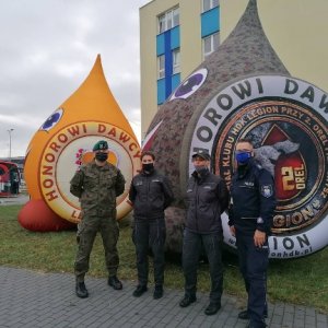 Przedstawiciele służby więziennej, wojska i ostrołęckiej Policji przy nadmuchiwanych kropelkach symbolizujących krew