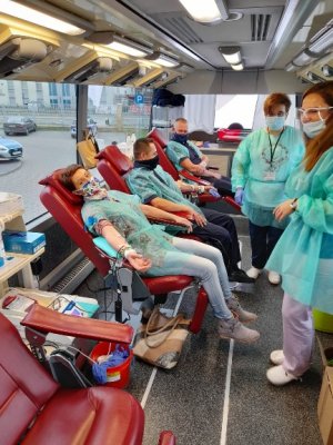 Funkcjonariusze Wydziału Ruchu Drogowego i Wydziału Prewencji Komendy Miejskiej Policji w Ostrołęce wraz z mieszkanką Ostrołęki podczas oddawania krwi w mobilnym punkcie poboru krwi