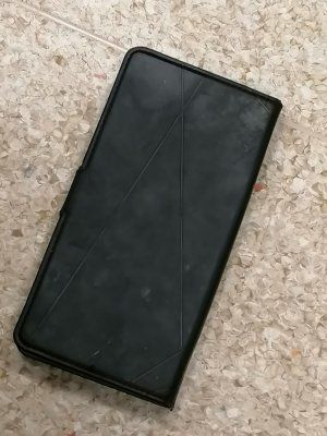 Na zdjęciu widoczny telefon komórkowy znajdujący się w etui (kolor czarny)