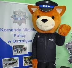 Na zdjęciu widzimy maskotkę policyjną Komisarza Kurpika ( miś), w tle baner KMP w Ostrołęce