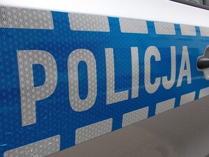 Na zdjęciu napis policja na drzwiach oznakwoanego radiowozu