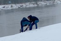 Na zdjęciu dwóch nieumundurowanych policjantów wydostają mężczyznę, który wpadł do rzeki
