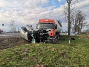 Na zdjęciu pojazd ciężarowy i osobowy, który leży  uszkodzony na boku