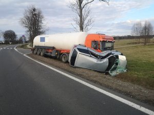 Na zdjęciu pojazd ciężarowy i osobowy, który leży  uszkodzony na boku