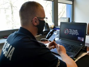 policjant siedzący przed komputerem