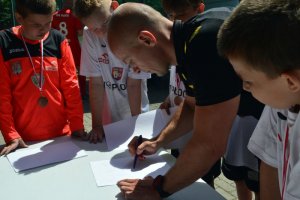 Pan Szymon Marciniak rozdaje autografy młodym piłkarzom