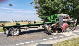 ciągnik rolniczy z naczepą przewrócony na drodze w wyniku zderzenia z innym pojazdem
