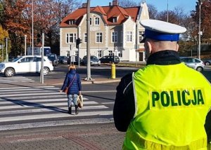 policjant i pieszy przechodzący przez przejście dla pieszych
