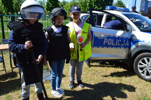 trójka dzieci ubrana w policyjne kamizelki