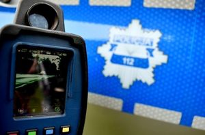 policyjnej laser do pomiaru prędkości pojazdów na tle radiowozu Policji