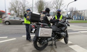 policjanci wraz z motocyklistą na drodze