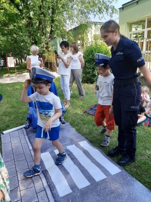 policjantka z dziećmi podczas spotkania bezpieczne wakacje