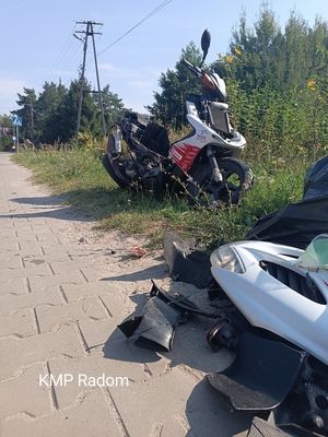 Miejsce zdarzenia drogowego w miejscowości Wojciechów. Na zdjęciu widoczny motorower z licznymi uszkodzeniami.