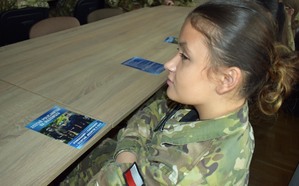 uczennica klasy mundurowej i ulotka informacyjna o naborze do służby