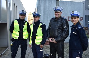 Czworo policjantów z radomskiej drogówki. Od prawej strony policjantka w mundurze, następnie policyjny motocyklista w skórzanym stroju i dwaj policjanci umundurowani w kamizelkach