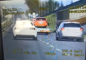 zdjęcie z policyjnego videorejestratora, widać  auta w tym białe audi, którego kierowca przekroczył prędkość i wyprzedzał na przejściu