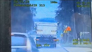 zdjęcie z policyjnego videorejestratora, widać pojazd który wyprzedza policyjny radiowóz, a w tle pojazd ciężarowy