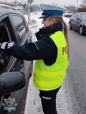 policjantka podczas służby kontroluje trzeźwość kierowcy