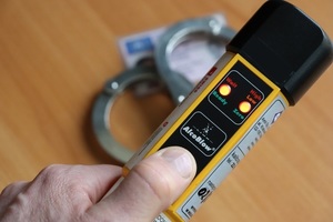 żółte urządzenie do badania stanu trzeźwości w tle kajdanki