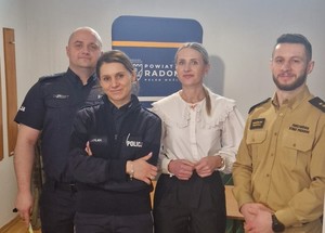 na zdjęciu 4 osoby, od lewej dwoje policjantów, kobieta - rzecznik praw konsumenta starostwa powiatowego w Radomiu, a po prawej strażak