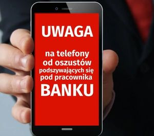 telefon, a na ekranie komunikat uwaga na oszustów podających sie za pracowników banku