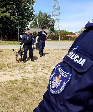 dwaj policjanci i pies słuzbowy podczas prelekcji na plaży nad zalewem na Borkach