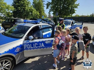 grupa dzieci i policjantka przy radiowozie