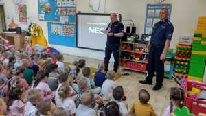 policjanci odczytujący bajkę dzieciom