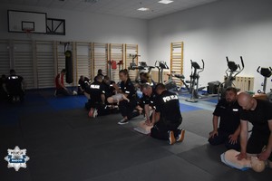 na sali gimnastycznej grupa policjantów podczas szkolenia z pierwszej pomocy