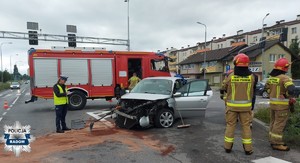 policjantka na miejscu zdarzenia, obok rozbity samochód strażacy i wóz strażacki