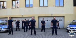 grupa policjantów stoi przed komendą