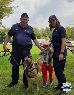 dwoje policjantów, chłopiec i policyjny pies słuzbowy