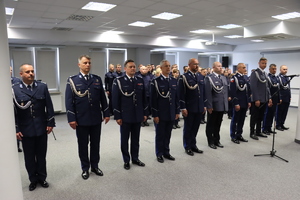 grupa oficerów stoi na srodku sali konferencyjnej