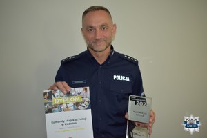 Zastępca Komendanta trzyma statuetkę i dyplom dla Komendy Miejskiej Policji w Radomiu dla Najaktywniejszej Instytucji w Dniu Przedsiębiorczości