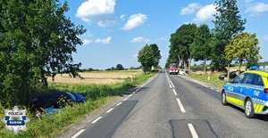 miejsce wypadku i dwa pojazdy w rowie, widac radiowóz na drodze